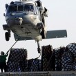 An MH-60S picks up supplies at sea.