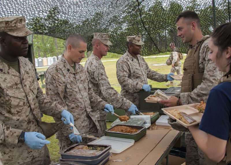 U.S. Marine Corps food service specialists with 1st Battalion, 10th Marine Regiment, 2nd Marine Division serve unitized group rations to Marines and their families during a Jane Wayne Day event aboard Camp Lejeune, N.C., June 6, 2014. The purpose of the event was to give family members a chance to better understand what their loved ones do in the Marine Corps. (U.S. Marine Corps photo by Sgt. Christopher Q. Stone, COMCAM, MCI-East, Camp Lejeune/Released)